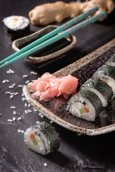 Maki rollos de sushi con salmón y aguacate en la vendimia japonesa —  Fotos de Stock