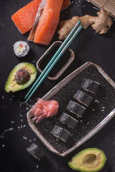 Maki rollos de sushi con salmón y aguacate en la vendimia japonesa —  Fotos de Stock