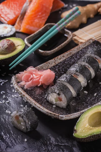 Maki rollos de sushi con salmón y aguacate en la vendimia japonesa —  Fotos de Stock