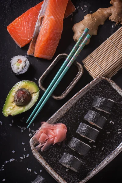 Maki-Sushi-Röllchen mit Lachs und Avocado auf dem alten Japaner — Stockfoto