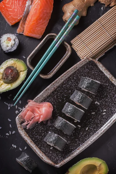 Maki-Sushi-Röllchen mit Lachs und Avocado auf dem alten Japaner — Stockfoto