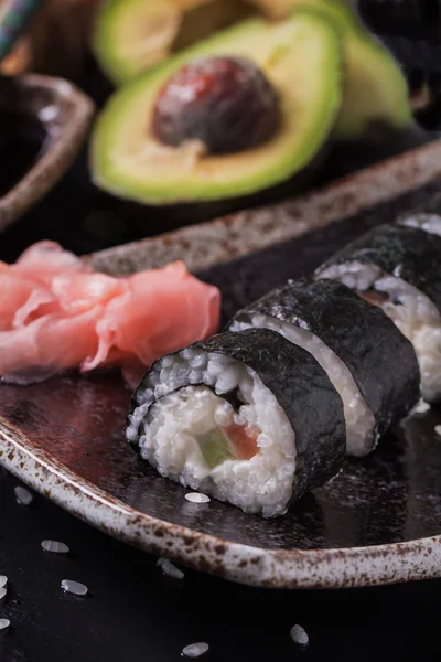 Maki-Sushi-Röllchen mit Lachs und Avocado auf dem alten Japaner — Stockfoto