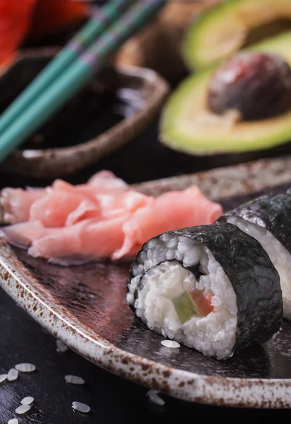 Maki-Sushi-Röllchen mit Lachs und Avocado auf dem alten Japaner — Stockfoto