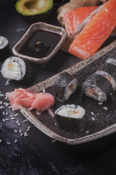 Maki rollos de sushi con salmón y aguacate en la vendimia japonesa —  Fotos de Stock