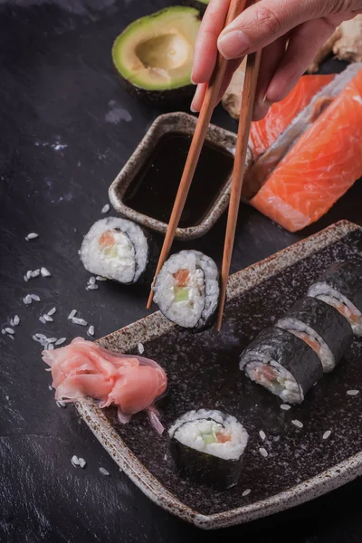 Maki-Sushi-Röllchen mit Lachs und Avocado auf dem alten Japaner — Stockfoto