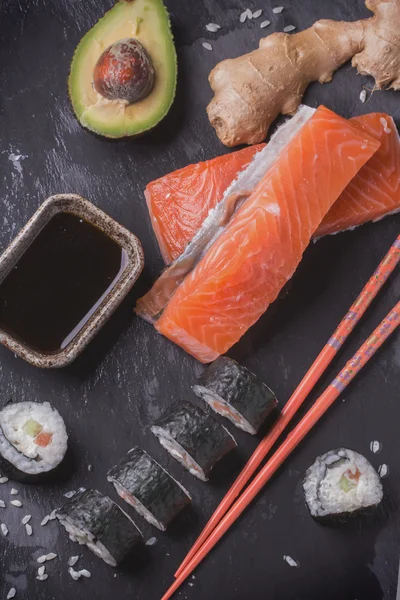 Maki rollos de sushi con salmón y aguacate en la vendimia japonesa —  Fotos de Stock