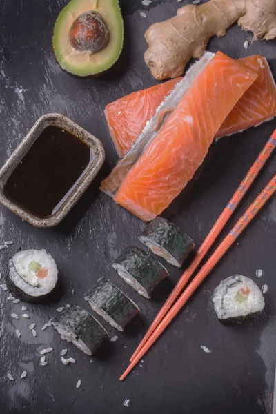 Maki-Sushi-Röllchen mit Lachs und Avocado auf dem alten Japaner — Stockfoto