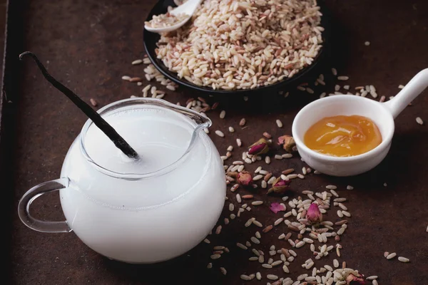 Leche de arroz con granos de arroz, miel y rosas secas — Foto de Stock