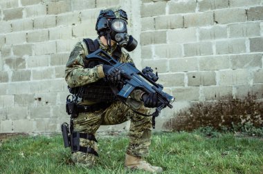 Cropat desenli üniformalı silahlı özel kuvvetler askeri M95 gaz maskesi ve saldırı tüfeği GK G36 giyiyor..