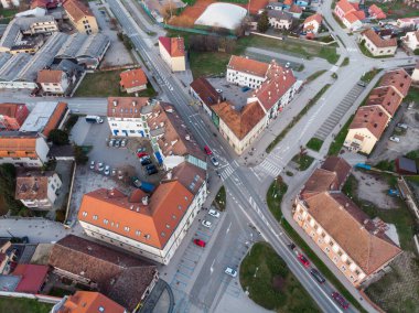 Koprivnica Şehri, Hırvatistan. Şehir merkezinin panoramik drone fotoğrafları kışın gün batımında çekildi. Şehir caddesi, park ve kilise manzarası.