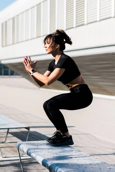 Jumping on the bench. Girl doing jump exercise outdoors. Fit woman healthy lifestyle concept.