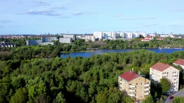 位于瑞典斯德哥尔摩南部的湖 斯堪的纳维亚半岛 雅斯塔郊区的空中无人驾驶飞机夏季飞行景观 有高大的白色公寓楼 森林树 公园和绿地 — 图库视频影像