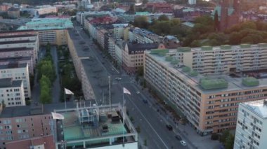 Kentsel binaların, çatıların ve sokakların üzerinde uçan insansız hava aracı görüntüsü. Hornsgatan, Hornstull ve Hgalidsparken 'e doğru, Stockholm, İsveç, İskandinavya' da yaz akşamı.