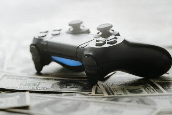 Concept of gaming addiction. Close up photo of gamepad on the money background. — Stock Photo, Image