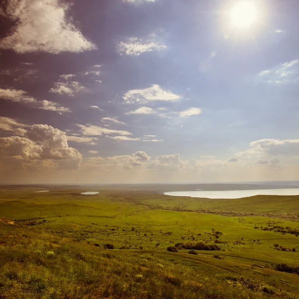 Foto van prachtige landschap met gras begroeide land onder zonnige hemel in vintage stijl — Stockfoto