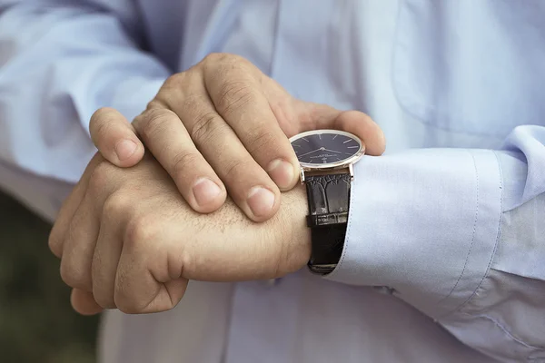 Zakenman die hand in hand kijken op zijn horloge Stockafbeelding