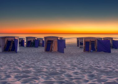 Sahil kulübeleri Katwijk aan Zee, Hollanda 'da günbatımı geçmişiyle