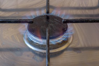 Yanan bir gaz sobasının yanına.