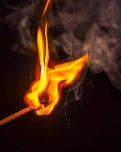 A matchstick gets fire on a dark background