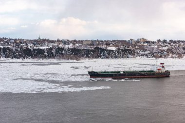 Quebec şehri, Quebec, Kanada 14 Mart 2021: Günbatımında, Quebec kentinin önündeki St. Lawrence nehri üzerindeki kış trafiği görülüyor.