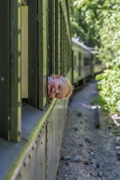 Niño sonriente mirando por la ventana de un tren —  Fotos de Stock