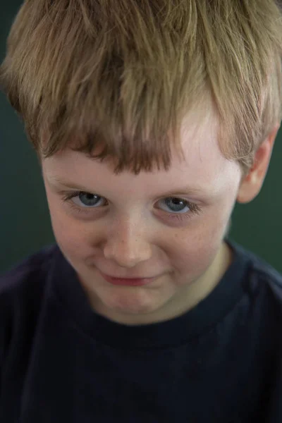 Young blonde boy trying to look grumpy — Stock Photo, Image