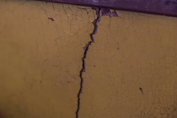 Büyük çatlak ve çatırdayan boyalı eski bir duvar.