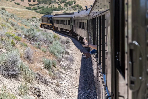 Hareket halindeki bir trenin camından sarkan kadın ayakları