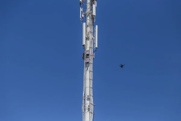 Drone inspecionando uma torre de celular no canto inferior direito — Fotografia de Stock