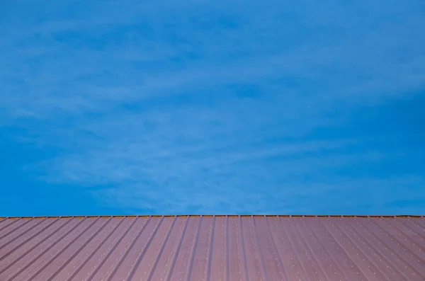 Parlak mavi gökyüzü ile kırmızı ahır çatısı