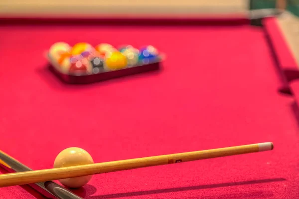 Kırmızı bilardo masası, toplar ve ıstakalar.