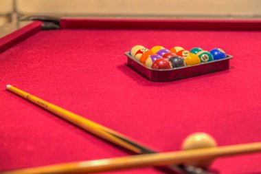 Kırmızı bilardo masasında bilardo topları var.