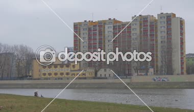 Çocuk oturan yeşil banka kuşlar vardır uçan küçük bir kız nehir banka Cityscape insanlara karşı banka bulutlu, bir kuşlar martılar güvercinler güvercin besleme