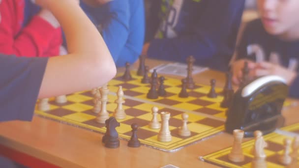 Los chicos en el tablero de ajedrez están jugando Hablando Los chicos están mirando el juego Los niños están jugando al ajedrez en la competencia de ajedrez Para niños preescolares en Opole Polonia — Vídeo de stock