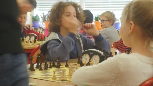 Flickor på schack styrelser lockigt Funny Girl blond flicka pojkar barnen spelar schack på schack konkurrens för förskolebarn i Opole Polen — Stockvideo