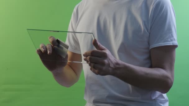 Man Types a Number of a Credit Card Attentively With Virtual Tablet Buys Through Internet Working on Forex Exchange Young Man in a White T-Shirt — Stock Video