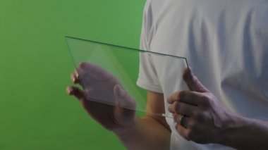 Adamın elleri yakın Scrolls ekran yürür uzakta sanal Tablet satın aracılığıyla Internet çalışma Forex Döviz konuşmayı Skype genç adam beyaz T-Shirt üzerinde