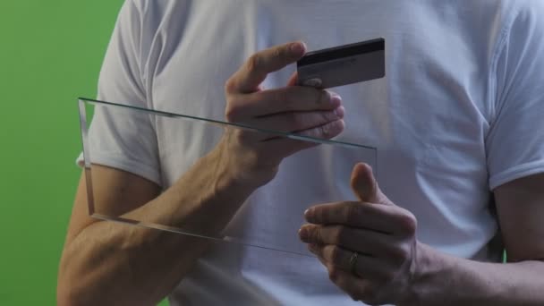 Empresario tiene una tarjeta de crédito escribiendo tabletas virtuales compra a través de Internet Trabajando en Forex Exchange Hablando por Skype Joven con camiseta blanca — Vídeo de stock