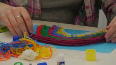 Eller çocuk çocuklar sınıfta masada oturan bir gökkuşağı renkli parçacığı yapıyoruz kağıt yardımcı olur şarap bir diziye yapıştırma