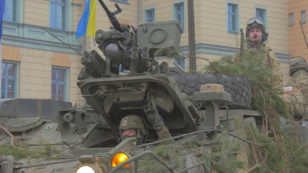 Collectieve beveiliging missie NAVO opleiding legers op de Tank zijn Wacht Tank is dat gemaskeerd met groene Pine takken Oekraïens vlag is zwaaien op een gebouw — Stockvideo