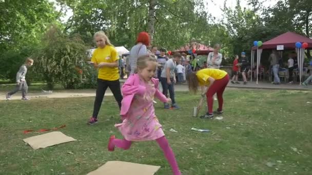 Çocuklar, çalıştırılan yarış, kağıt parçası atlama şişe bükme — Stok video