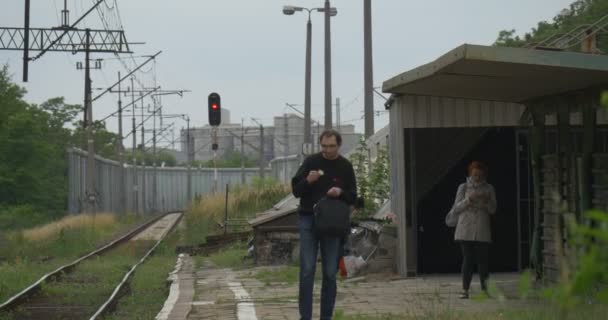 Dva lidé čekají na elektrická vlak — Stock video