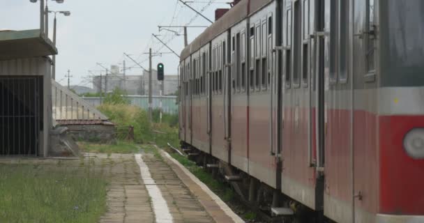 İnsanlar gelir konvoy kırmızı Elektrikli tren yapraklarda — Stok video