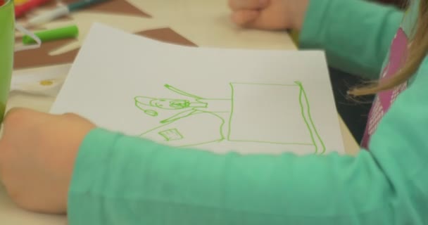 Маленька дівчинка малює на білому папері — стокове відео