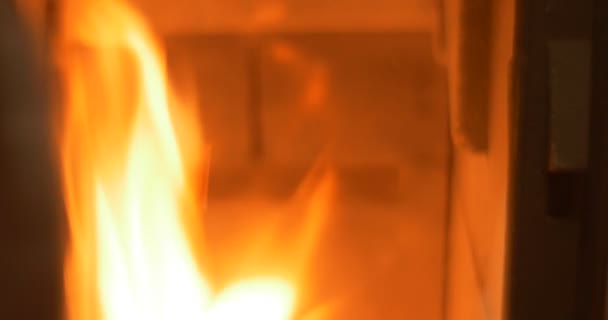 L'homme ouvre une petite porte d'un four à métaux par une tige mince 