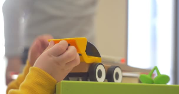 Маленький мальчик играет на машине в детском саду — стоковое видео
