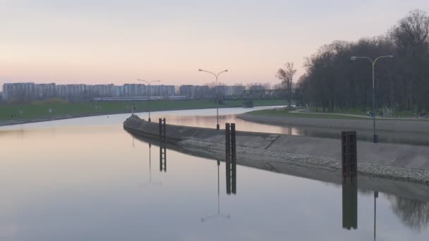Odra 강 물 부드러운 표면 포장의 은행 강 일몰 저녁 하늘에 부두의 보기는 물 표면 잔잔한 저녁에 반영 됩니다. — 비디오