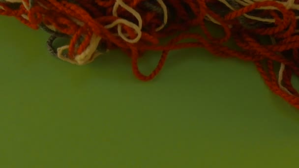 Μπερδεμένα μαλλί νήματα νήματα σε πράσινο οθόνη πολύχρωμα νήματα είναι μετακίνηση κομμένα κομμάτια από νήματα κάποιος είναι το τράβηγμα ένα νήμα καταργεί τοποθέτηση — Αρχείο Βίντεο