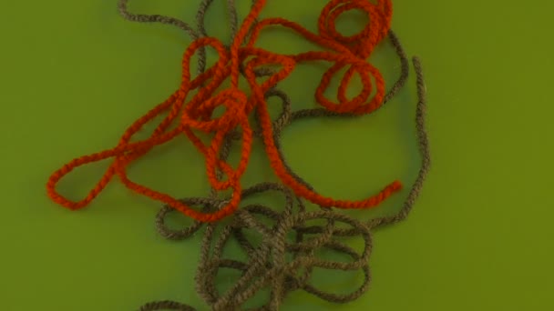 誰かが緑画面カラフルなフィラメント繊維手掛かり索スレッドは移動赤糸で引っ張ってもつれた糸はゆっくりと移動はウール スレッドの削除 — ストック動画