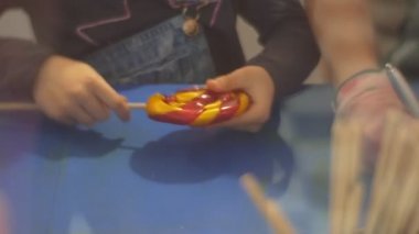 Bir Noel Candy kırmızı basarak bir karamel Candy yapmak bir çubuğa sabitleme öğretmen çocuk ve sarı şeker çocuklar fabrikaya tatlılar gezi yapmak için öğrenme